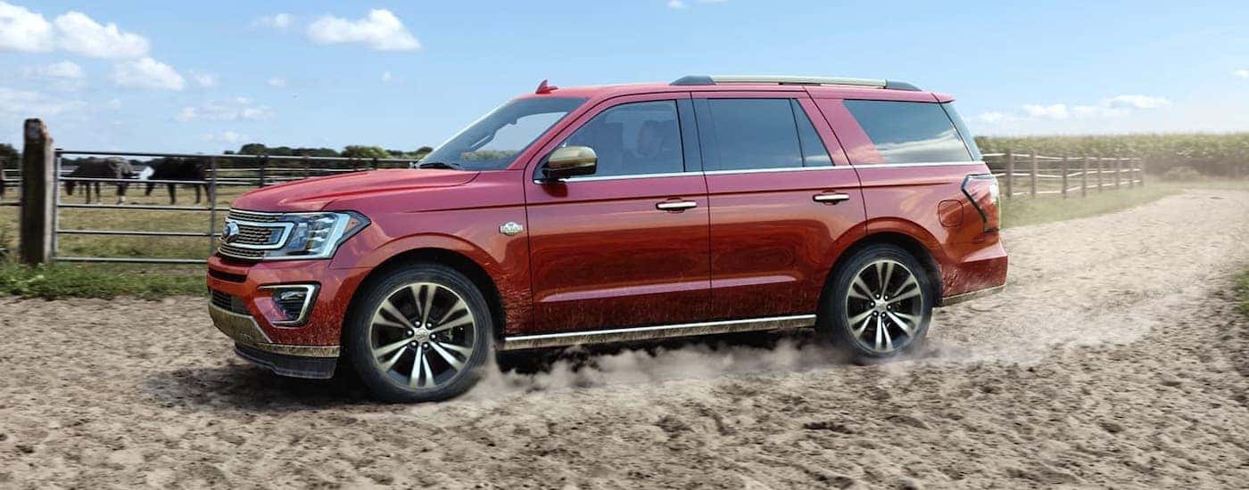 A red 2020 Ford Expedition King Ranch is driving past a horse farm near Cincinnati, OH.