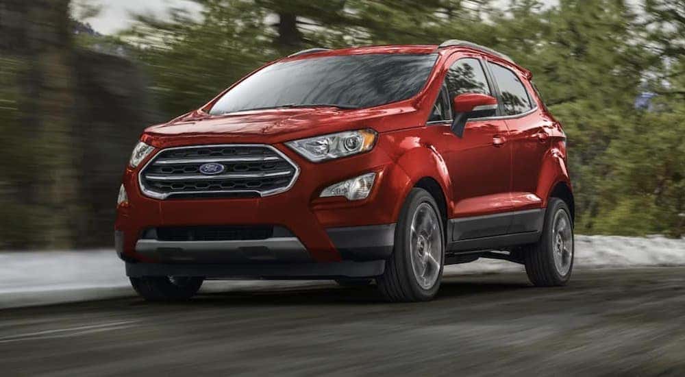 A red 2022 Ford EcoSport is shown from the front driving on an open road.