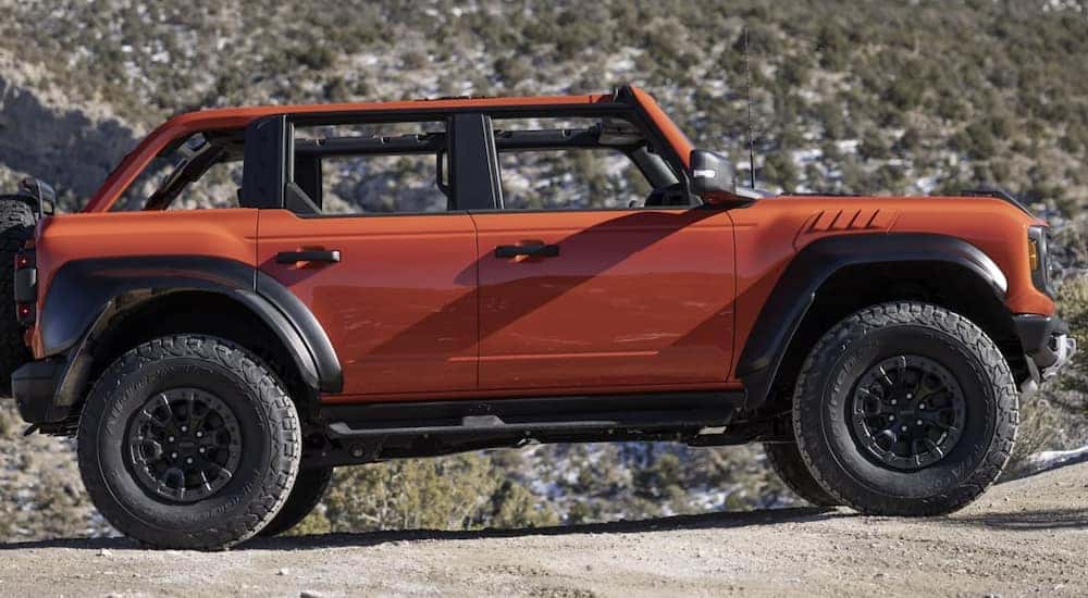 An orange 2022 Ford Bronco is shown from the side.