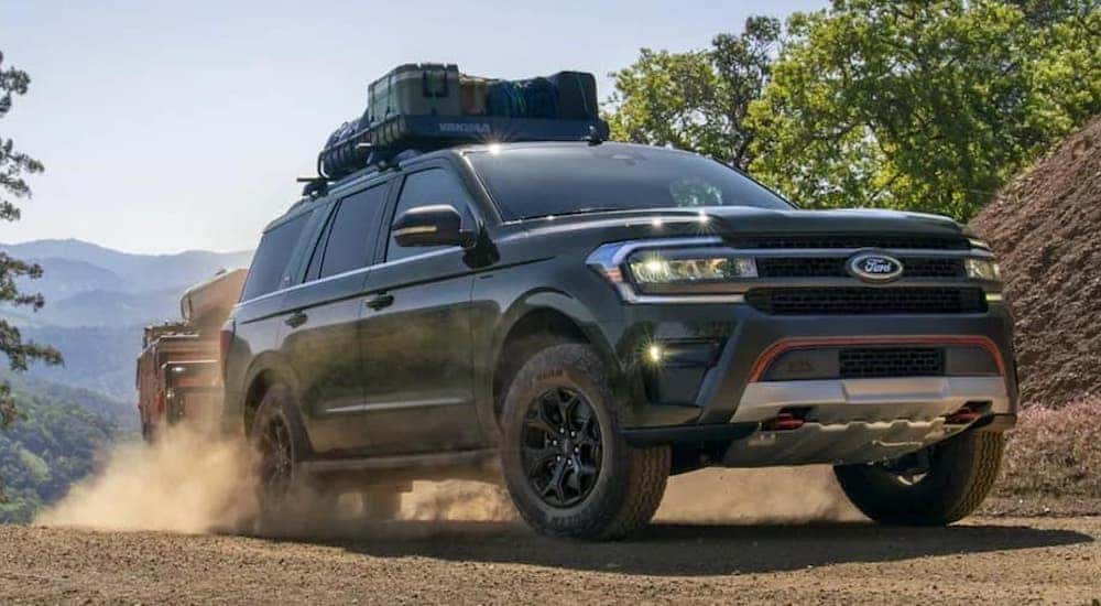 A green 2022 Ford Expedition is shown from the front driving on a dirt road.