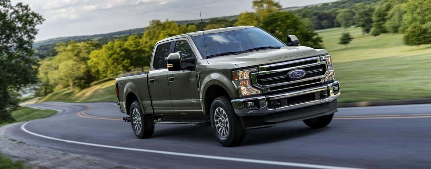A gray 2020 Ford F-250 is driving on a rural road.