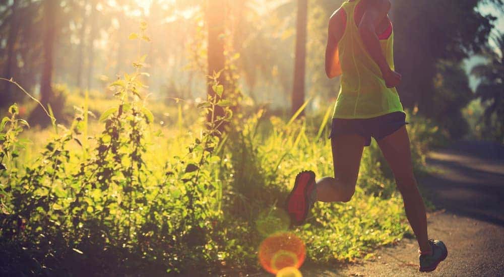 A woman is jogging in a sunny park.