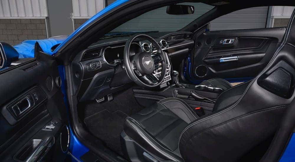 The black interior of a 2021 Ford Mustang Mach 1 is shown through the open door.