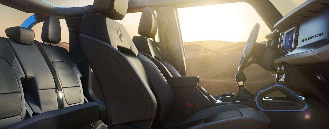 The black interior of a 2021 Ford Bronco 4-door Black Diamond with the doors off is shown from the passenger side.