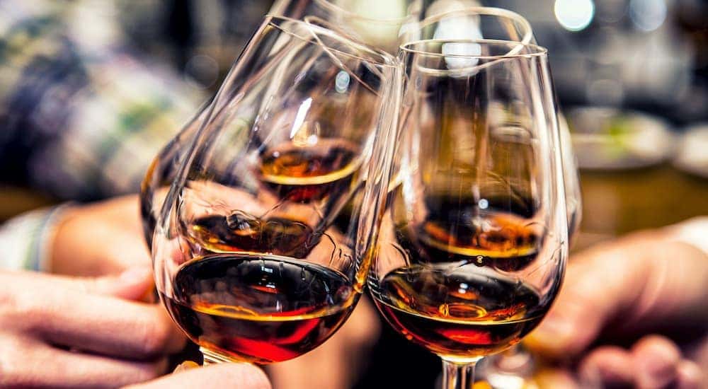 A close up is shown of people toasting wine glasses.