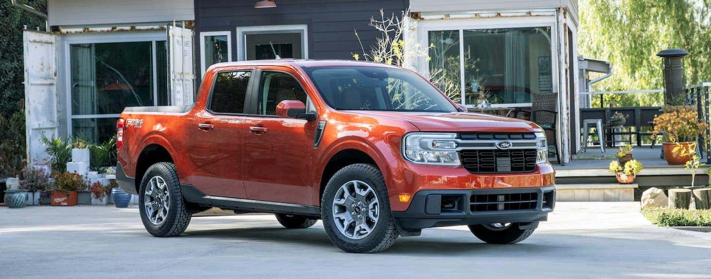 An orange 2022 Ford Maverick Lariat is shown in a driveway after being purchased from a Cincinnati Ford Maverick dealer.