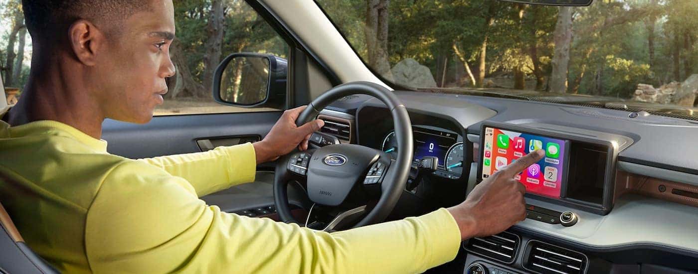 A man is shown using the touch screen in a 2022 Ford Maverick.