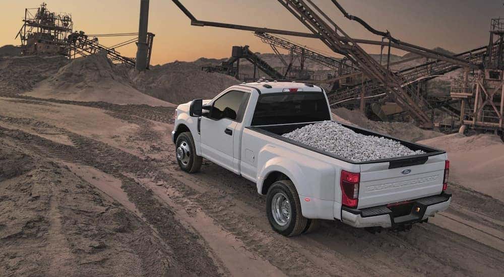A white 2022 Ford F-350 Super Duty is shown carrying gravel on a construction site.