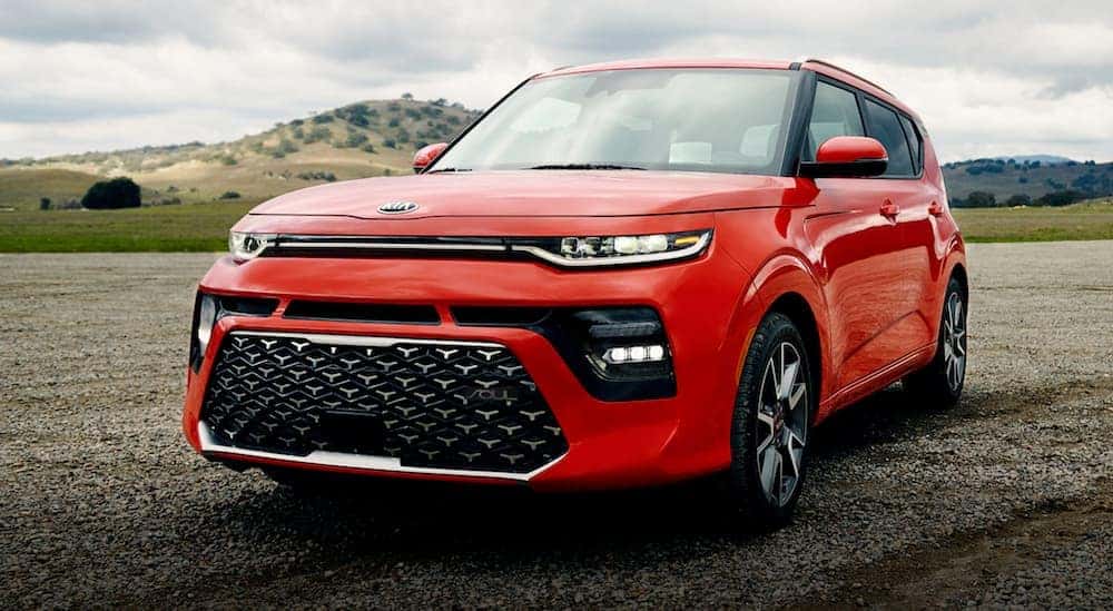 An orange 2021 Kia Soul is shown parked in a remote location.