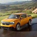 An orange 2022 Ford Maverick is shown driving after going through the Ford pre-order process at a dealership.