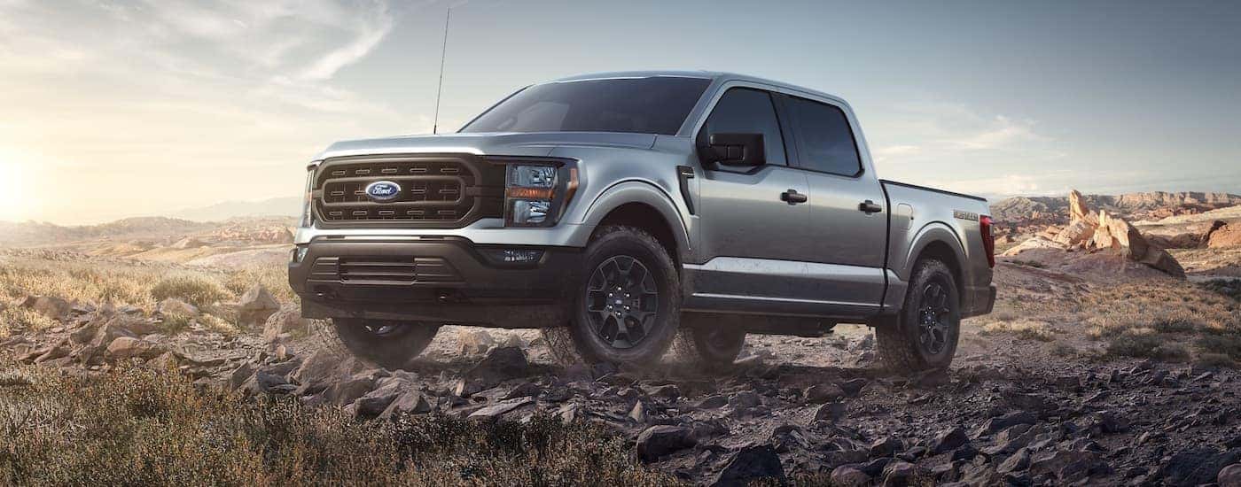 A silver 2023 Ford F-150 Rattler is shown parked on a rocks after leaving a Ford F-150 dealer.