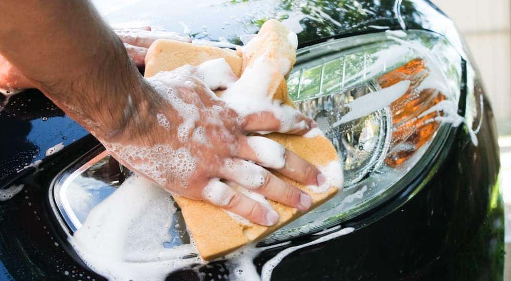 Close-up of a person washing their headlights in order to help sell their car