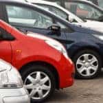 Row of red, white, and blue used vehicles on a car lot