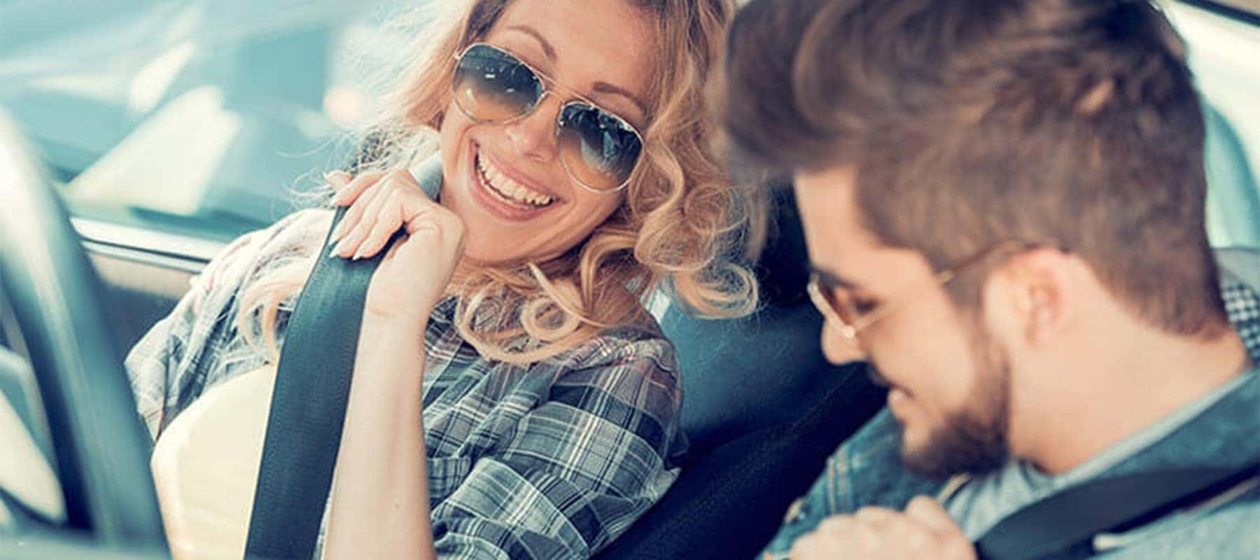 Two-People-Driving-In-Convertible-Smiling