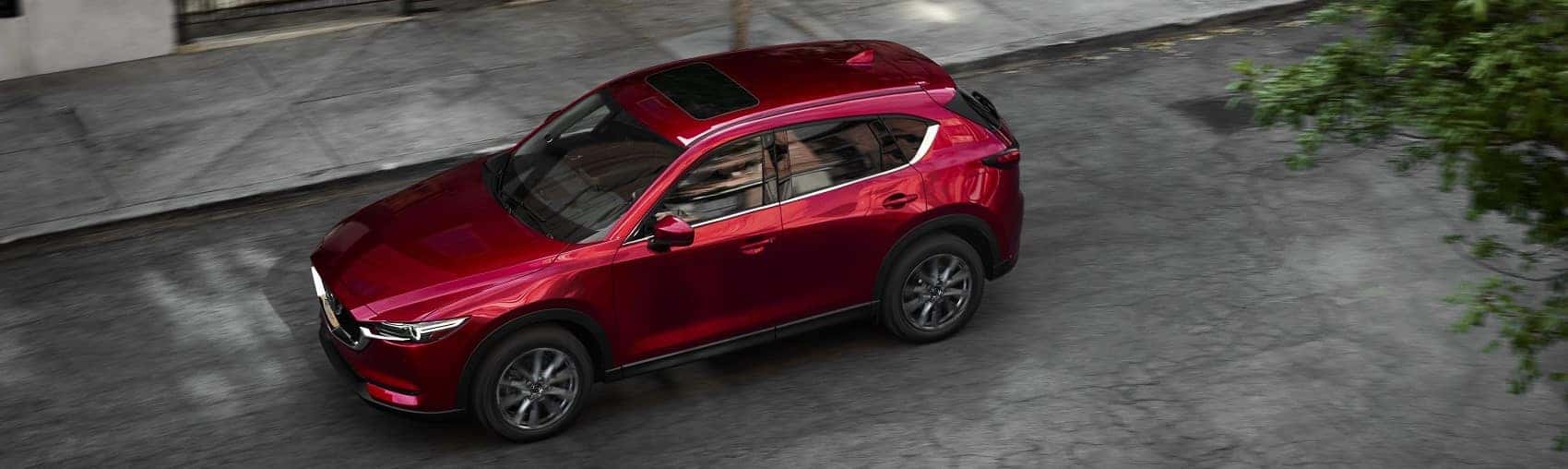 2021 Mazda CX-5 red driving through a city banner