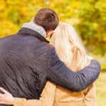 couple hugging in autumn park from back