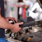 auto mechanic using diagnostic equipment on vehicle