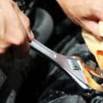 Hand with wrench. Auto mechanic in car repair