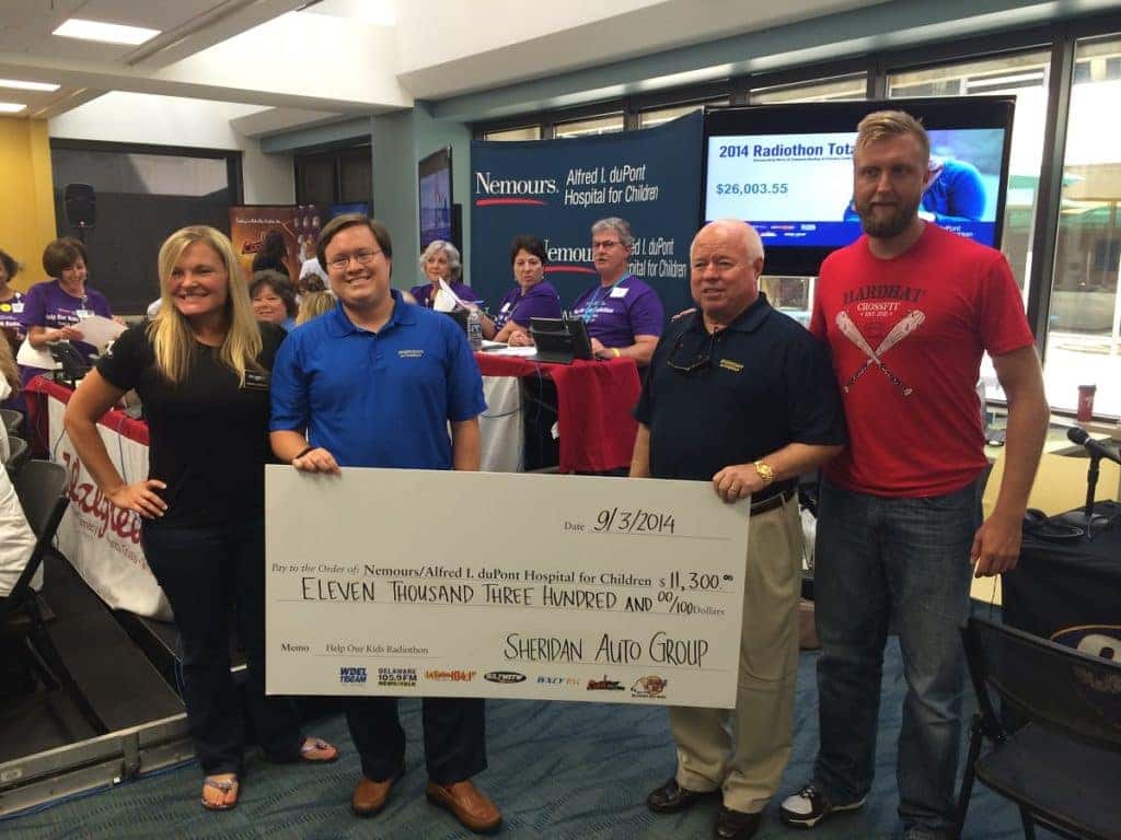Chip and Joe Sheridan donating check to Members of Nemours Foundation in 2014