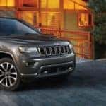2018 Jeep Grand Cherokee parked outside a cabin in the woods