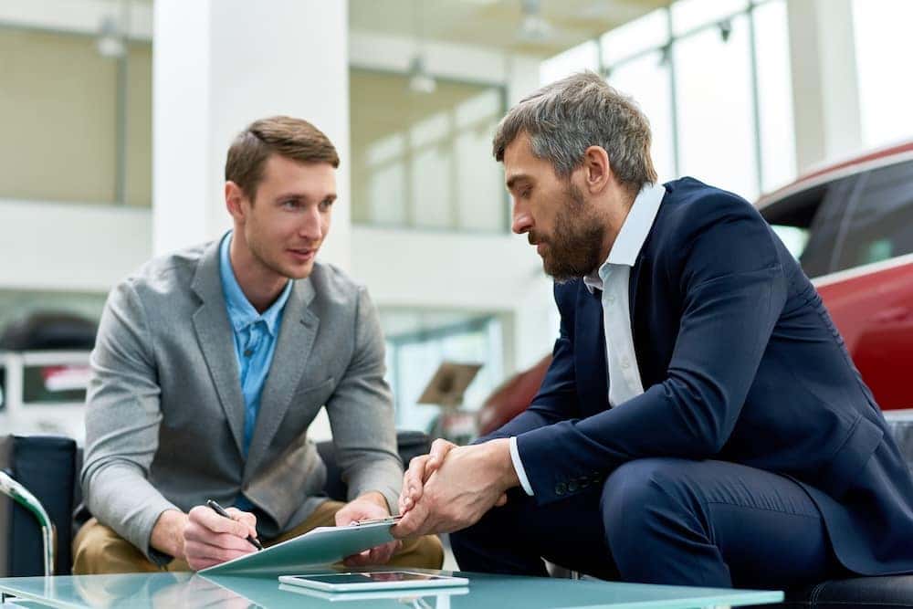 Sales Advocate and customer reviewing vehicle financing paperwork