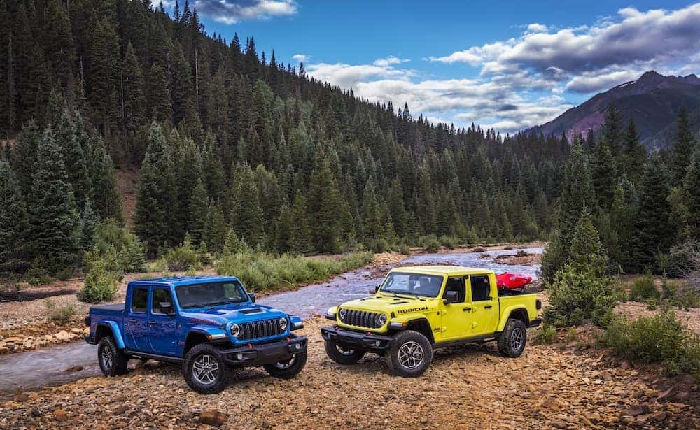 Blue and yellow 2024 Jeep Gladiator trucks off-roading