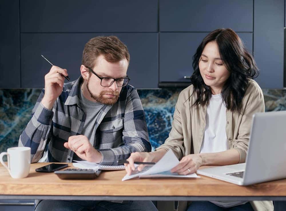 man and woman reviewing their budget for car shopping