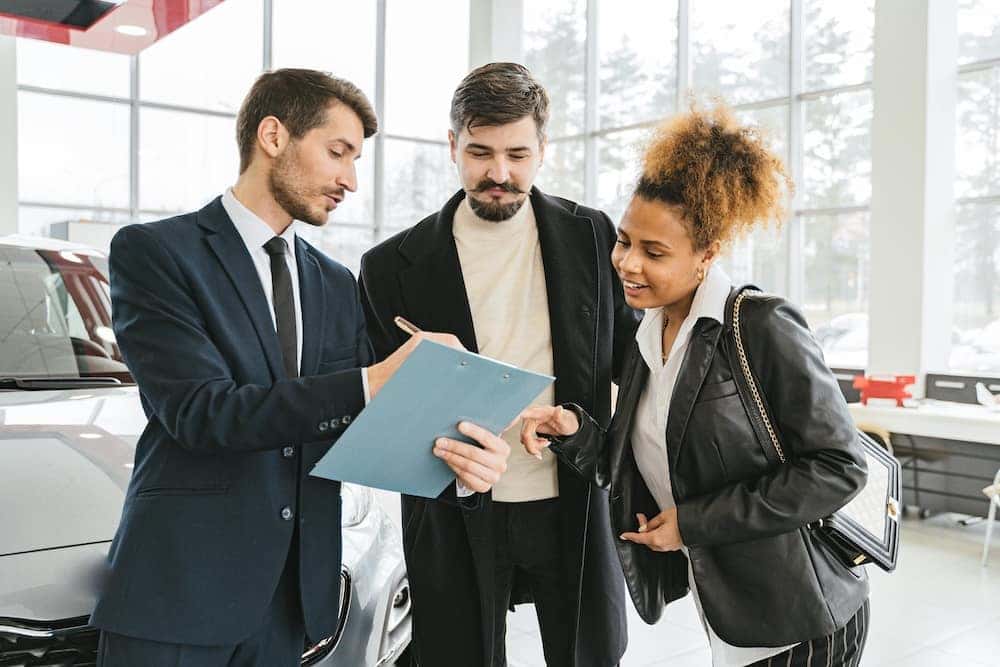 Man and woman car shopping and buying a car