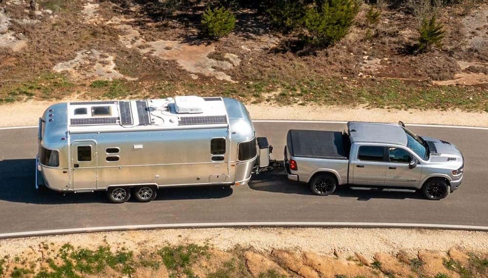 2025 RAM 1500 towing a trailer displaying the RAM 1500 towing capacity