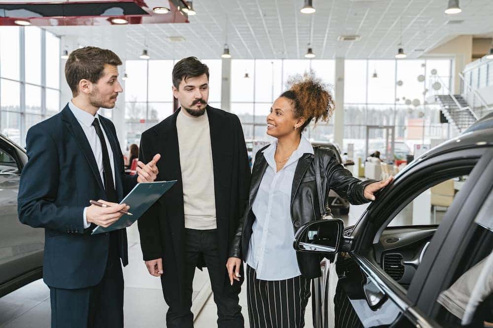 Man and woman speaking to a Sales Advocate and buying a car in person