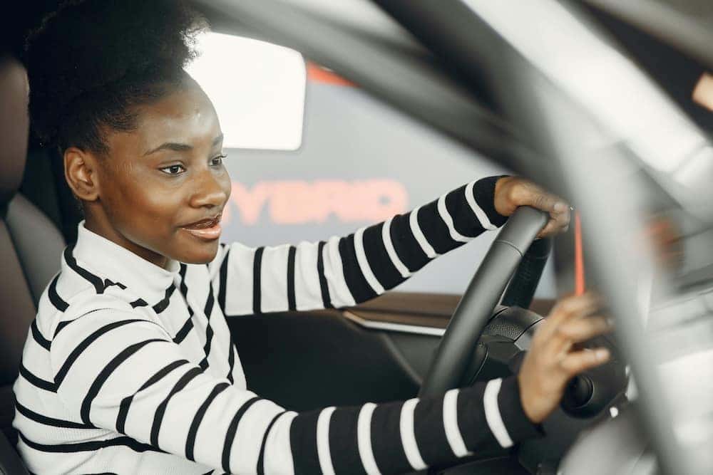 Woman test driving a car before buying a car in person
