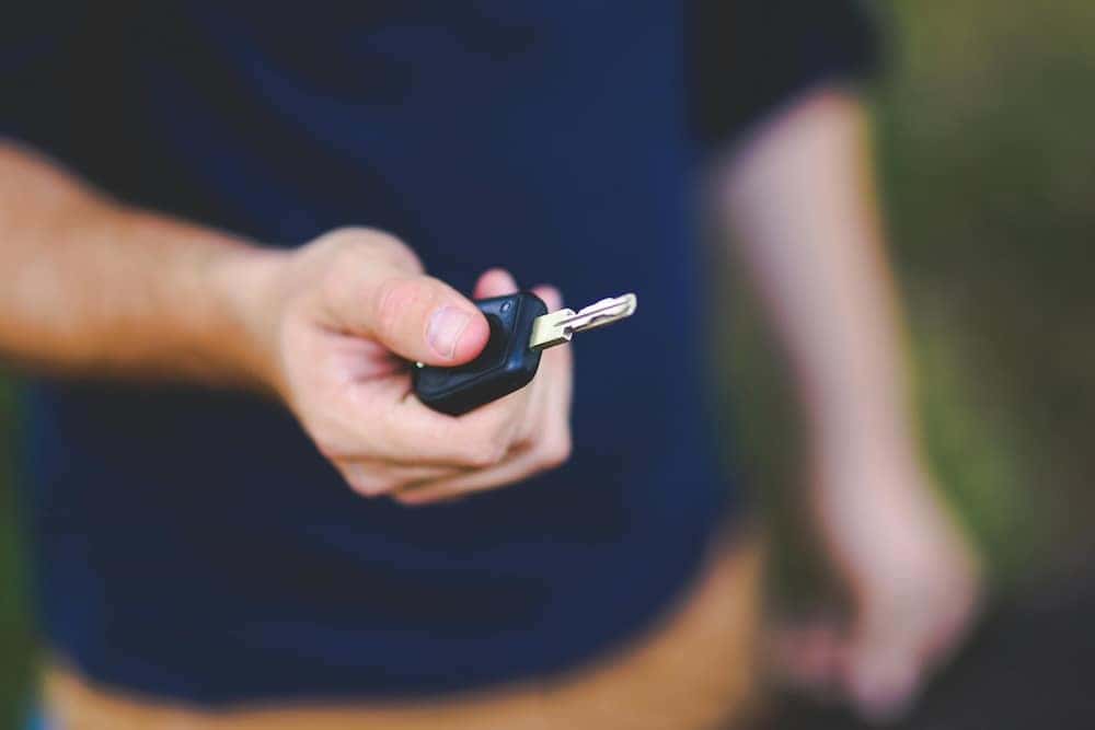 Man holding out a car key