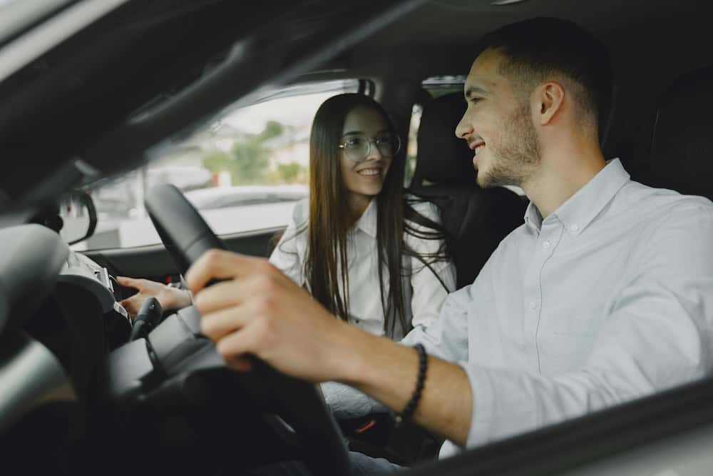 Man and woman test driving a car