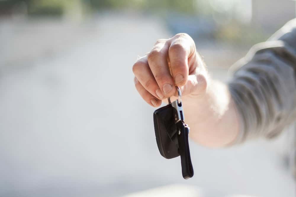Person handing over car keys to trade in a car