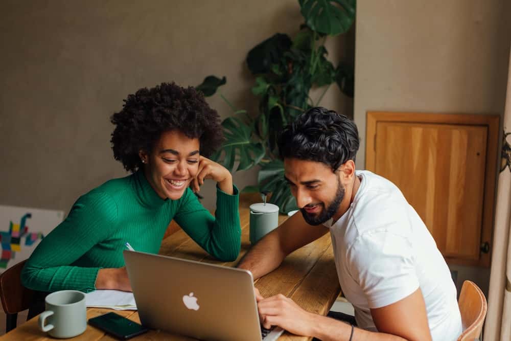 Man and woman looking at their vehicle's trade-in value on their computer