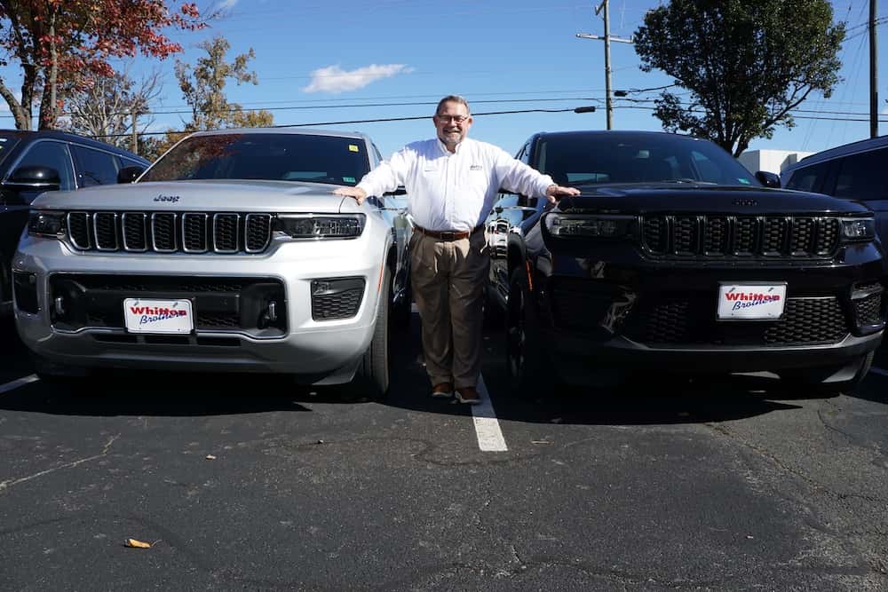 Sales Advocate standing in front of two Jeep SUVs