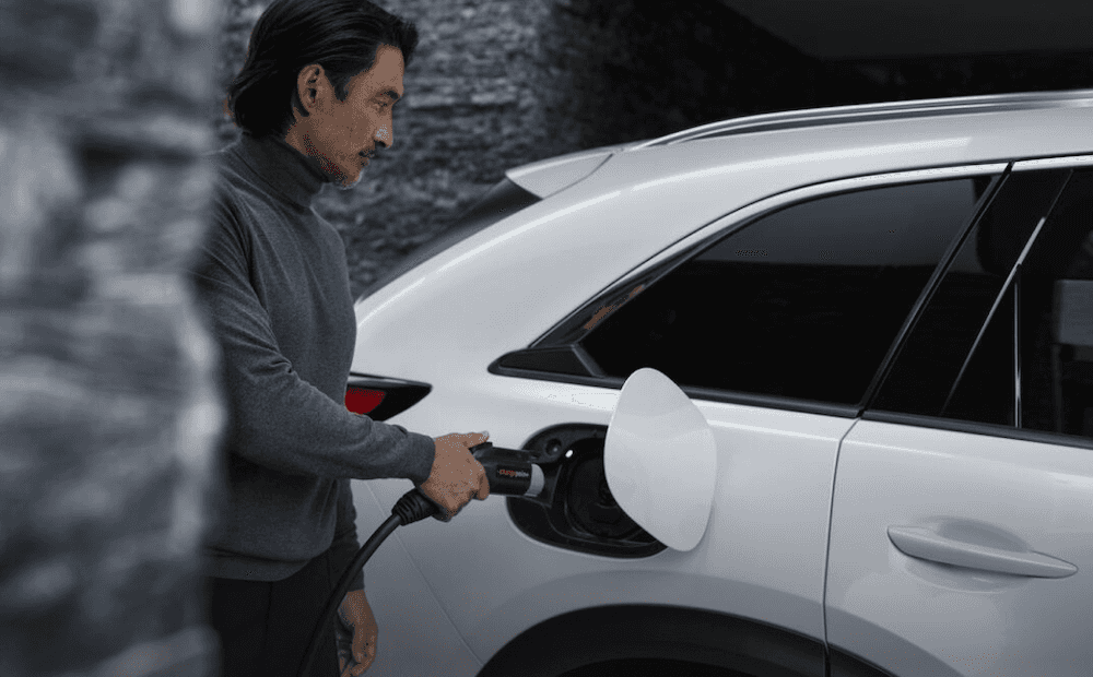 A man charging the Mazda CX-90 PHEV SUV