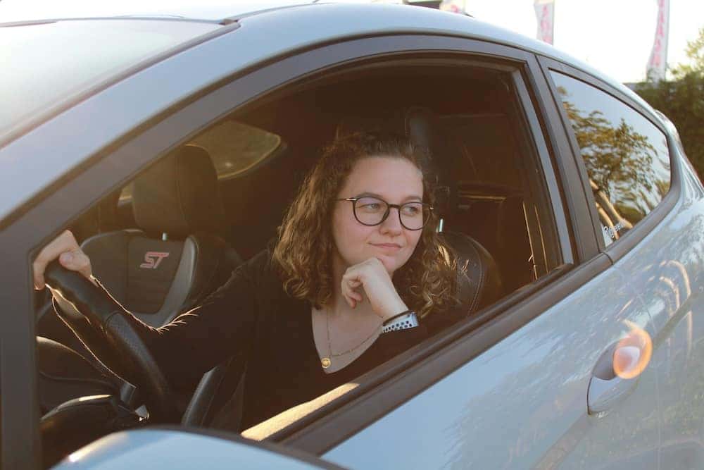 Where's the Best Place to Buy Used Cars in Richmond? A woman is sitting in a used car thinking about her upcoming purchase.