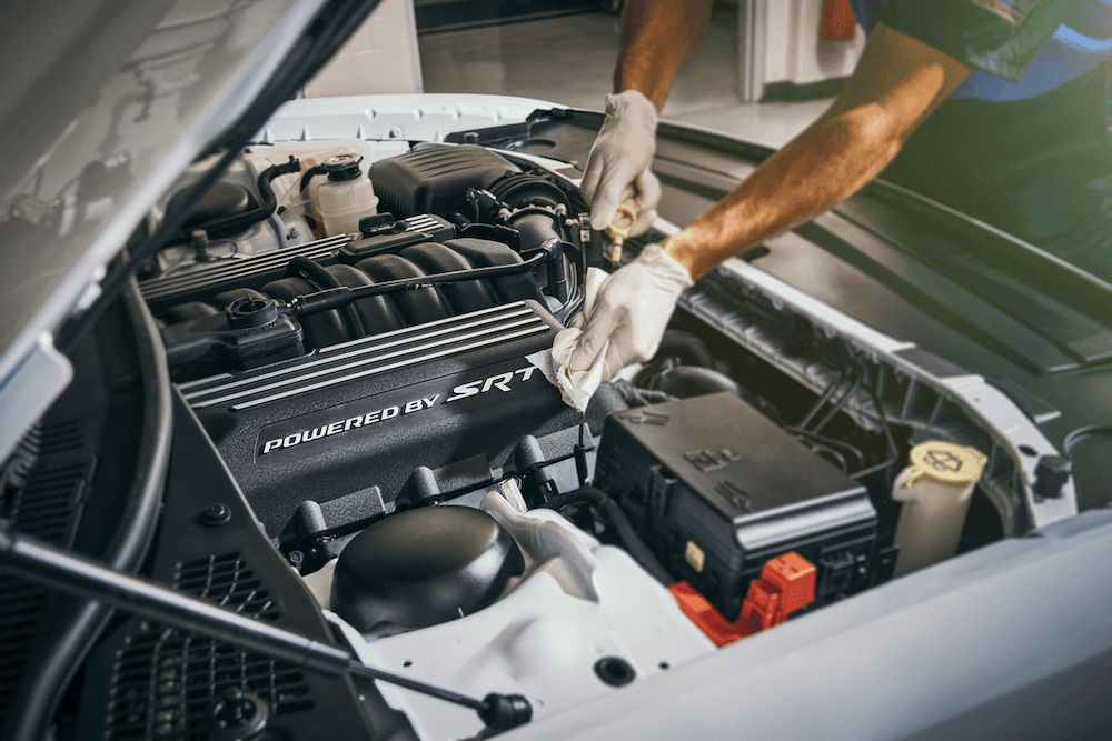 Auto service technician changing oil