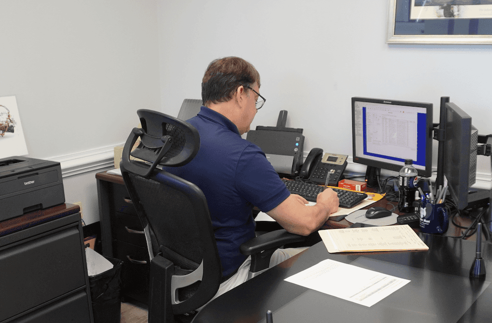 Whitten Brothers Automotive employee reviewing vehicle trade in paperwork
