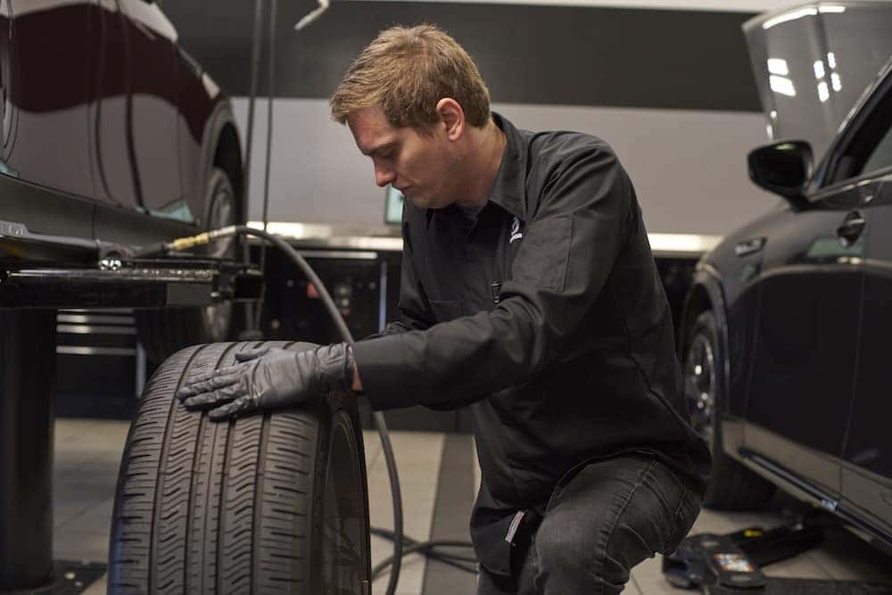 Mazda service technician changing a tire on a Mazda SUV