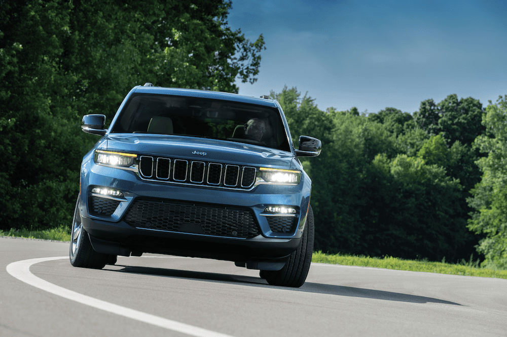 Jeep Grand Cherokee 4xe driving on a road. Jeep hybrid SUV.