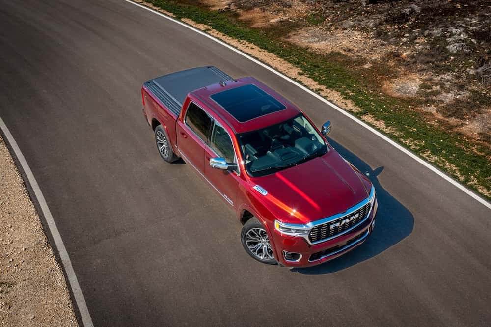 Red 2025 RAM 1500 driving on a road
