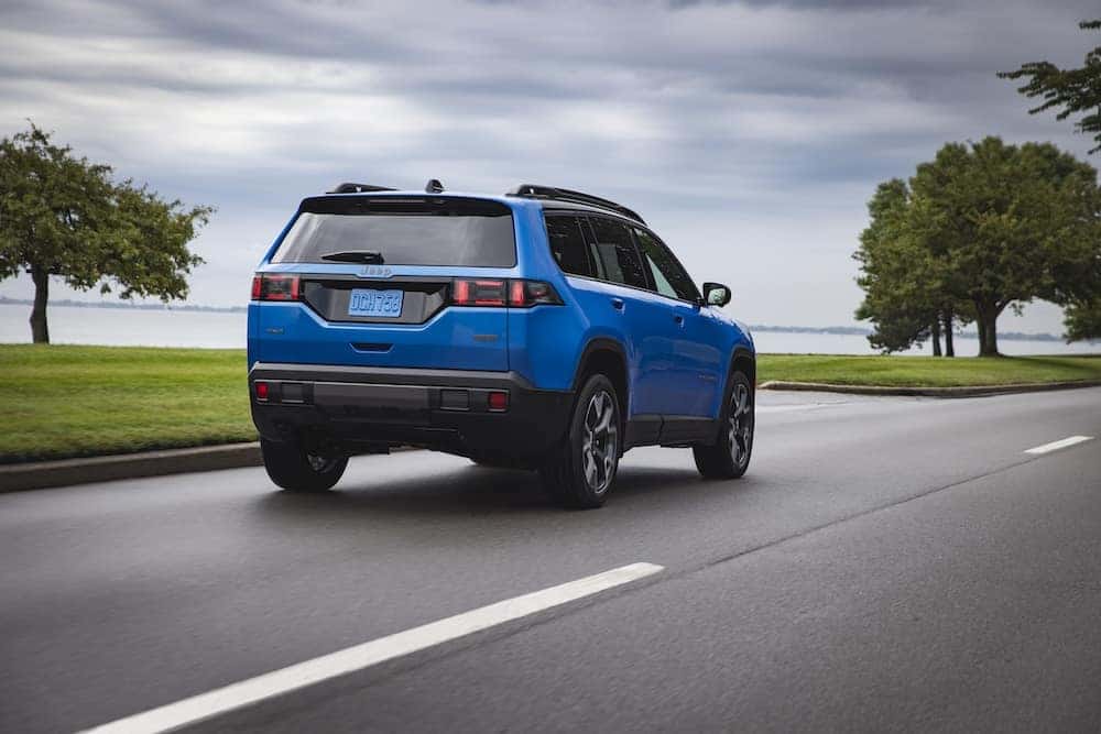 Rear view of the 2026 Jeep Grand Cherokee driving on a road