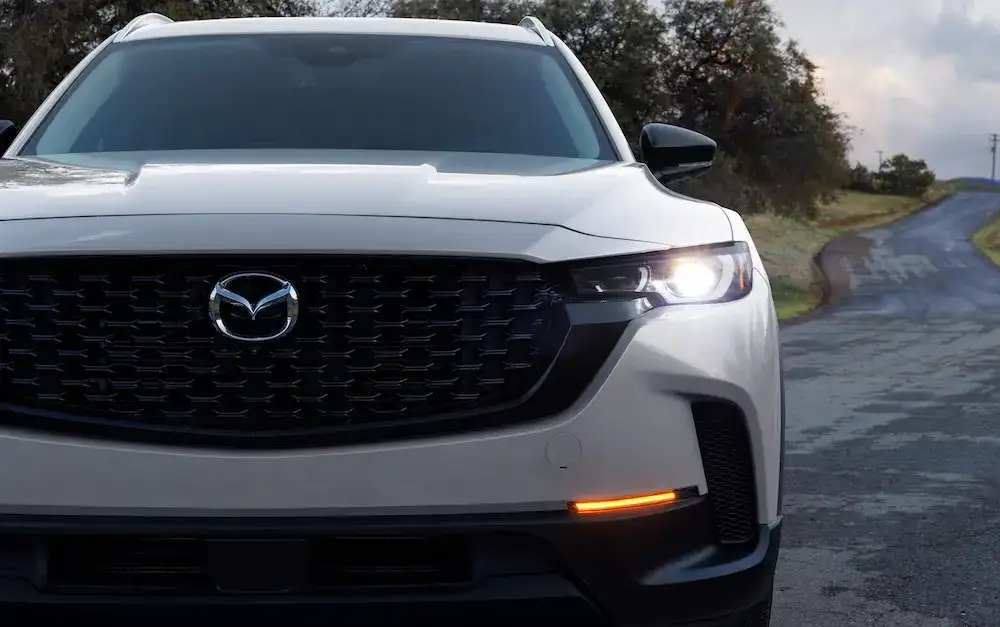 2025 Mazda CX-50 Hybrid exterior with headlights on