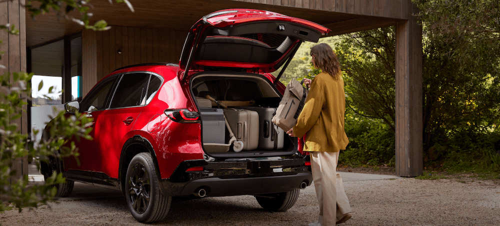 2026 Mazda CX-5 cargo space. A woman putting groceries into the Mazda CX-5 trunk.