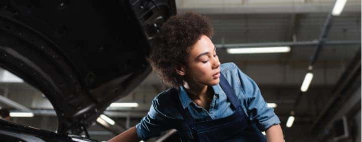 Female service technician working on vehicle