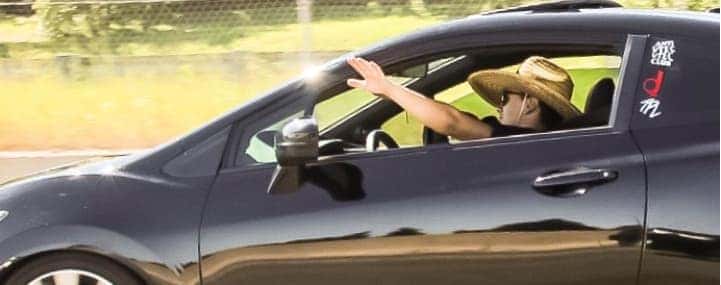 Man waving out of car window